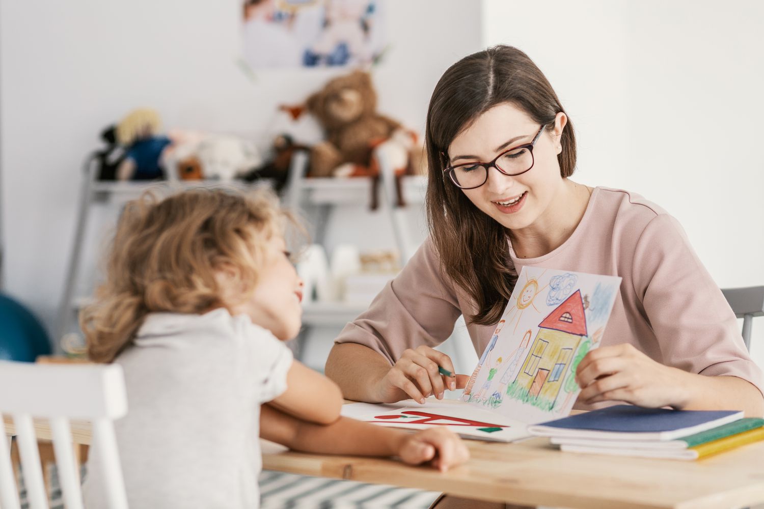 a professional child education therapist having a meeting with a kid in a family support center 1011888356 3db3abdc5d9a4a7c871574ae2d1665b9